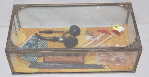 Vintage Counter Showcase w/ Collectibles: Vintage Counter Showcase w/ Collectibles: embossed tin frame w/glass; contains a small beaded change purse; a paper fan; 3 tin thimbles; wooden thimble stand; a packet of 100 cigar labels, assorted; F