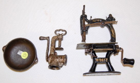 3 Cast Iron Toy Items, Sewing Machine: 3 Cast Iron Toy Items: 1.) Midget Sewing Machine; 7 3/4" T. (There is some beginning corrosion on the platform.) 2.) Baby Meat Grinder; 4 1/2" L. (Metal finish worn.) 3.) 3 Footed Kettle marked No 15 
