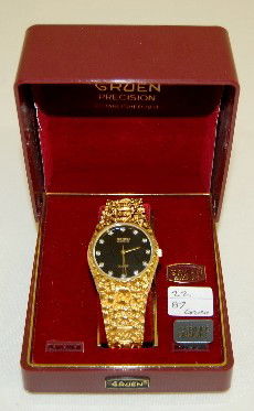 Gruen Electric Wrist Watch in Box: Gruen Electric Wrist Watch in Box: the black dial has Gruen Diamond Quartz on it and gold hands with 12 diamonds as markers; on a faux gold nugget band; not tested, unable to open the case. All Items