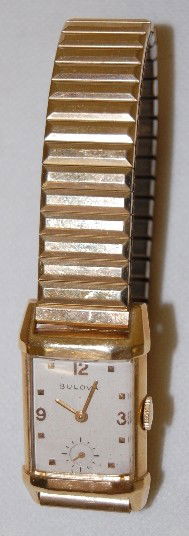 Bulova 14K, 21J, 7AK Wrist Watch: Bulova 14K, 21J, 7AK Wrist Watch: S.N. 8033250; the white dial has gold hands, numbers and markers. In a 14K yellow gold case; on a Speidel flex band. Running at this time. All Items Sell As Is, Where