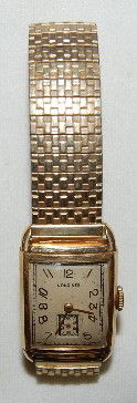 Longines 9L, 14K, 17J, GJS, Wrist Watch: Longines 9L, 14K, 17J, GJS, Wrist Watch: S.N. 6831752, Unadj.usted, A silver dial with gold hands and numbers. In a Keystone / Longines 14K yellow gold case numbered 2053019. On a Speidel flex band. (