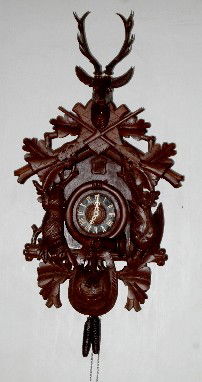 Black Forest Game Carved Cuckoo Clock: Black Forest Game Carved Cuckoo Clock: the case is carved with a hanging rabbit and pheasant, horn and game bag; the crest is a buck head with antlers and 2 rifles. Deer and rabbit have glass eyes. Pl