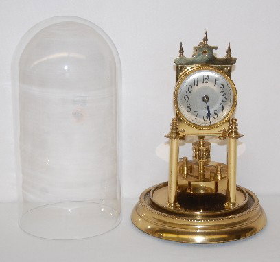 Germany Disk Pendulum Anniversary Clock: Germany Disk Pendulum Anniversary Clock: silver metal dial; rotating disk pendulum; works marked Made in Germany No. 105595. Running. (Minute chips to rim of dome.) 12" Tall. All Items Sell As Is, Whe