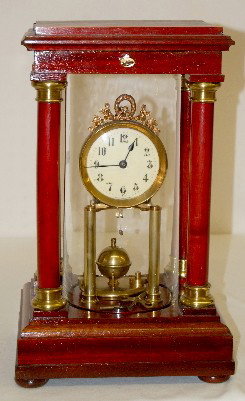 Gustav Becker Disk Pendulum Anniversary Clock: Gustav Becker Disk Pendulum Anniversary Clock: has 2 keys; K.C. Germany marked dial; brass movement marked Gustav Becker No. 2194279; in a wood 4 column case with a glass tube and locking top. (Keys d