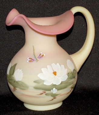 Fenton Glass Burmese "Water Lily" Pitcher: Fenton Glass Burmese "Water Lily" Pitcher: with dragonfly; marked with a paper label and "F designed by Frances Burton; Fenton hand painted by M. Wagner #972/1450". No condition problems. 7 3/4".