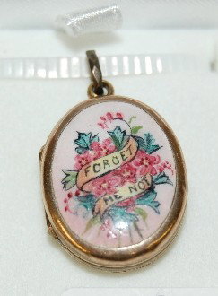 Locket With Enamel "Forget Me Knot": Locket With Enamel "Forget Me Knot": small size, gold colored metal with engraving on one side; enameled on the other side. Unmarked. It is 7/8" L.