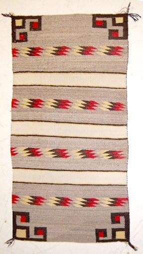 Navajo Weaving, Circa 1910-1935: Navajo Weaving, Circa 1910-1935: three light brown bands with red, black and off white bars across them; geometrics in the corners; in excellent condition. 31" x 60".