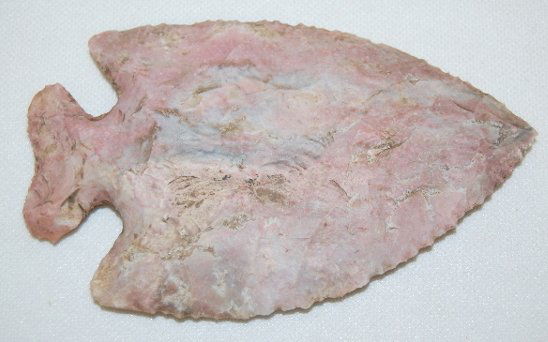Large Notched Point, 4 3/8" x 2 5/8": Large Notched Point, 4 3/8" x 2 5/8": made of a pinkish-purple granite like stone; the edges were made by taking large flakes off then fine flakes to form the edges.