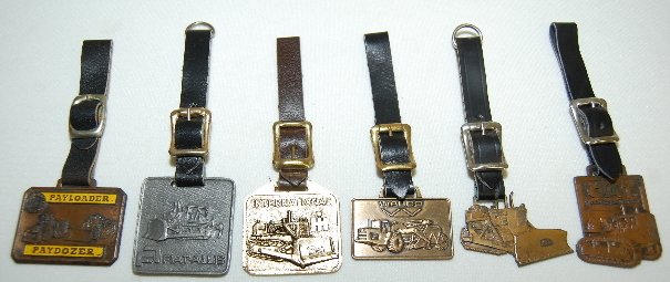 6 Watch Fobs: All Heavy Equipment: 6 Watch Fobs: All Heavy Equipment: 1.) W.A.B. Co. Miller Bradford & Risberg & Brass 2.) Payloader - Paydozer Rish Equipment Co.; made of brass, showing wear. 3.) Fiat Alliv-Earle Equipment; metal unkn