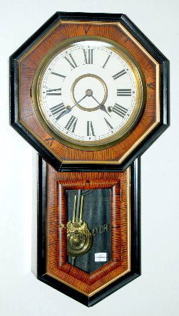 Seikosha Tiger Stripe Veneer Regulator Wall Clock: Seikosha Tiger Stripe Veneer Regulator Wall Clock: T & S, has pendulum, black and gold trim. 22" (Paint faded on the lower door.)