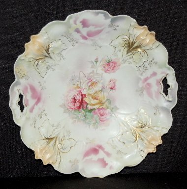 RS Prussia "Iris" Cake Plate, #25 Mold: RS Prussia "Iris" Mold #25 Cake Plate: Marked RS Prussia and Gesetzlich geschtiezt; center of pink, yellow and white roses; edge molded with 4 iris blossoms. No condition problems. 9 3/4" Dia.