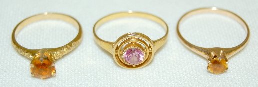 3 - 10K Gold Rings: All Set With Stones: 3 - 10K Gold Rings: 1.) Marked ES, set with tourmaline with a circle within a circle setting with a 1/2ct pinkish tourmaline in the center; size 7 1/2. 2.) Marked with an EN joined trademark; 1/4ct ye