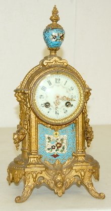French Japy Freres & Cie Clock: French Japy Freres & Cie Clock: porcelain dial; T&S; w/ champleve insert and finial; metal case w/ cherub head & garland; w/ pendulum. 14" x 6" No condition problems.
