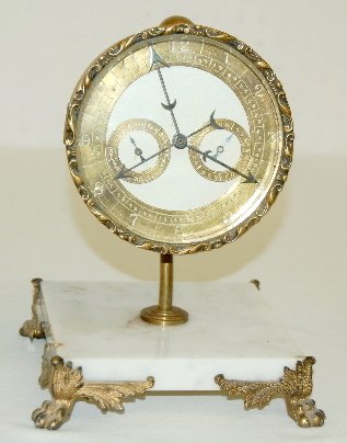 Waterbury Calendar Desk Clock, 3 Dials: Waterbury Calendar Desk Clock, 3 Dials: Brass markers with enamel painted dial; 4 function. There is a brass scroll bezel and a marble base with paw feet. Not tested. (Repaired housing.) 10" x 7" x 7"
