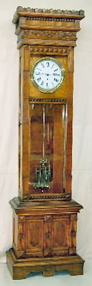 Oak Gilbert #12 Jewelers Regulator Clock: Oak Gilbert #12 Jewelers Regulator Clock: Floor standing model; porcelain dial with sweep seconds hand; 3 glass jar pendulum. In an ornate carved case with dead beat escapement & retaining power. 102"