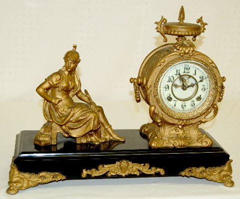 New Haven "Fame" Statue Clock: New Haven "Fame" Statue Clock: Marked porcelain double sunk dial with Arabic numbers and visible escapement; has pendulum and key; marked works. Not tested. (Has a clock repairer's label on the back.)
