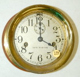 Seth Thomas Ships Clock, T & S: Seth Thomas Ships Clock, T & S: Has a metal silvered dial with a seconds hand. In a brass case mounted on a wood base. The clock is working. Dial 6"; Clock 7" x 3 1/2".