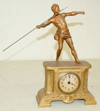 German Statue Clock, Male Javelin Thrower: German Statue Clock, Male Javelin Thrower: In a white metal case with gold and copper gilt; tab wind. Not tested. 14 1/2" x 8 1/4"