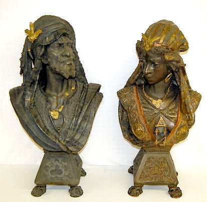 Pair Cast White Metal Nubian King & Queen Busts: Pair Cast White Metal Nubian King & Queen Busts: 1.) The king has a turban type striped head cloth with a 3 winged emblem; he is bearded and wears a charm necklace; has has a vest with a cloth draped 