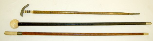 3 Antique Walking Canes: 3 Antique Walking Canes: 1.) Black wooden stick with an ivory ball top. 2.) Wood stick with a simulated bone or ivory handle; multi colored with a pressed metal band between the stick and the handle. 