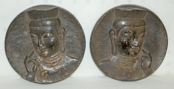 Pair of Cast Iron Buddha Plaques: Pair of Cast Iron Plaques depicting Buddha: designed to hang opposite of each other; circa late 19th century; ears are elongated; there are 3 characters in a vertical line on both; traces of gold pain
