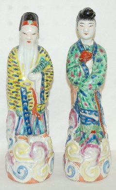 Pair of Old Chinese Porcelain Figures: Pair of Old Chinese Porcelain Figures: the bearded man wears a yellow robe covered with blue and pink enamel geometric designs. She wears a green robe with blue and purple floral shapes. The platforms