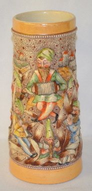 German Relief Gnome Beer Stein: German Relief Gnome Beer Stein: 1 liter; relief pottery with all over decoration of gnomes playing music & drinking; 2 oval medallions with words; a rams head molded handle; no lid; marked 780 Germany