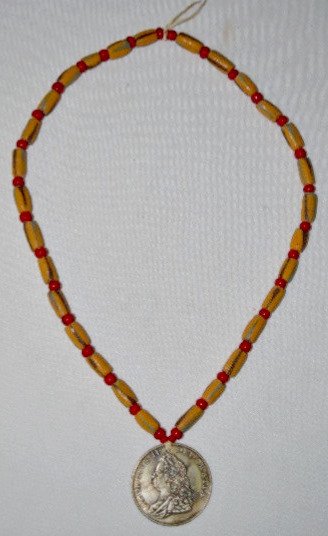 Trade Beads with George II Medal: Trade Beads with George II Medal: The early glass beads are solid colors of a yellow body with green and black stripes; separated by white cased red beads; the Georgius II Del Gratia silver plated med