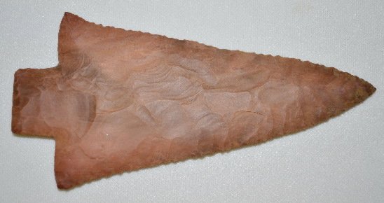 Native American Stone Spear Point: Native American Stone Spear Point: Made from a reddish brown material; it has a rectangular base and is not notched; the edges are nicely serrated but the angle of one does not match the angle of the 