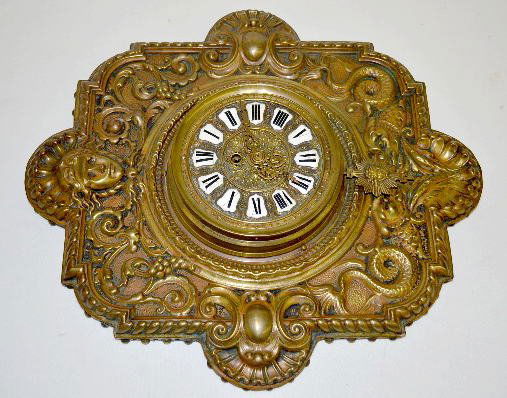 French Brass Hanging Wall Clock: French Brass Hanging Wall Clock: Marked "Fargot B. S.G.D.G. A. Paris 6303 1"; has embossed dolphins and shells, a lady head crest and cartouche porcelain numbers; with the pendulum. Not tested. 20" x