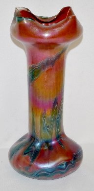 Vintage Loetz Style Iridized Glass Vase: Vintage Loetz Style Iridized Glass Vase: It is red iridized with very dark to light colored feather work; has a bulbous base with a long cylindrical body; the top has 4 pushed in sides; has a ground p