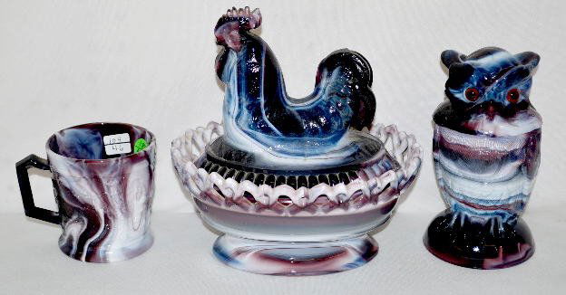 3 Pieces Imperial Glass, Purple Slag: 3 Pieces Imperial Glass, Purple Slag: 1.) Owl covered jar, molded, with glass eyes; marked; 6 1/2" T. 2.) Covered rooster, molded, with a lattice edge base; bot pieces are marked; 8" x 7 1/2". 3.) Mug