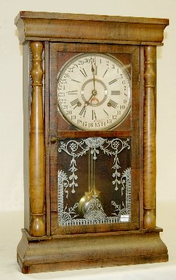 Gilbert Calendar Shelf Clock: Gilbert Calendar Shelf Clock: T & S; with a painted metal dial; in a veneered case with stenciled glass and 1/2 columns; with the pendulum. Not tested. 25" Tall (There is some veneer loss to the case.