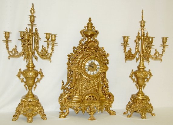 FHS Germany 3 Piece Clock Set: FHS Germany 3 Piece Clock Set: All brass with porcelain cartouche numbers and Roman numerals on an embossed dial; a marked FHS Germany movement; also marked 83 180-070; in a nice ornate case with mask