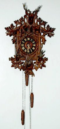 German Wall Hanging Cuckoo Clock: German Wall Hanging Cuckoo Clock: With carved stag head crest and 2 lower carved heads and hunting gear, decorated with acorn leaves, vines and a wreath; with the pendulum and 3 weights. Overall in gr