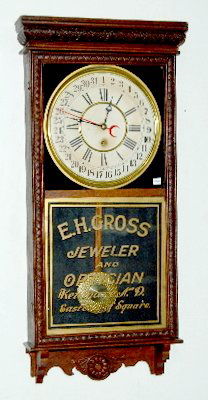 Sessions Advertising Hanging Regulator Clock, "E": Sessions Advertising Hanging Regulator Clock, "E": 8 day TO with a calendar dial; advertising "E.H. Gross, Jeweler and Optician, Kenmare, N.D. East Side of Square"; in an oak case with a dark finish;