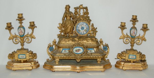 French Japy Freres Garniture Clock Set, 3 Piece: French Japy Freres Garniture Clock Set, 3 Piece: T & S with the movement marked Japy Freres; has a fancy floral dial; with a statue of a girl harvesting grapes; there are porcelain inset panels; has a