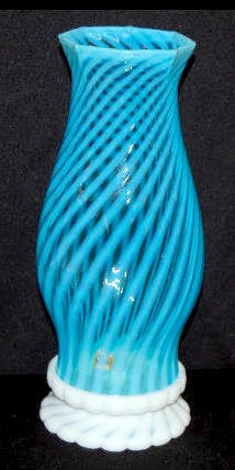 Fenton Blue Opalescent Spiral Hurricane Lamp: Fenton Blue Opalescent Spiral Hurricane Lamp: A white opaline glass base with a blue opalescent spiral shade; 8 sided top; the base has a candle hole; not marked. 10 3/4" Tall No condition problems.