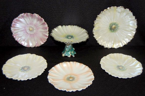 8 Pcs Royal Bayreuth Colored Poppy Tableware: 8 Pcs Royal Bayreuth Colored Poppy Tableware: White satin with gold trim pieces include: a cake plate; card stand and 2 saucers. There is one saucer in the peach satin. There are 3 saucers in the fuch