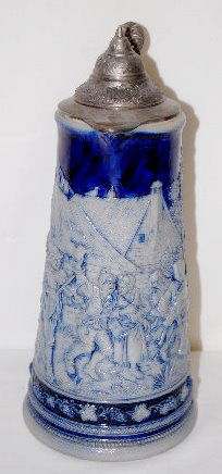German Stoneware 2 Liter Stein/Pitcher: German Stoneware 2 Liter Stein/Pitcher: Marked Simon Peter Gerz #207 B; relief molded scene, in blue and grey, of an outside dance, a house and a tree; has a grape arbor border; there is a tree limb h