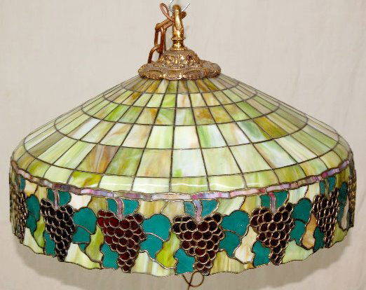 Leaded Glass Hanging Light Fixture with Grapes: Leaded Glass Hanging Light Fixture with Grapes: Made with green and caramel colors intermingled; has a 6 light fixture inside. 24 3/4" Diameter (There may be one or more hairlined glass pieces.)