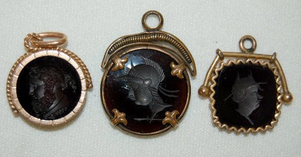 3 Victorian Watch Chain Charms: 3 Victorian Watch Chain Charms: all with intaglio profiles; they all look black, but 2, when held up to the light look like carnelian or honey amber. The smaller round charm is not translucent. All se