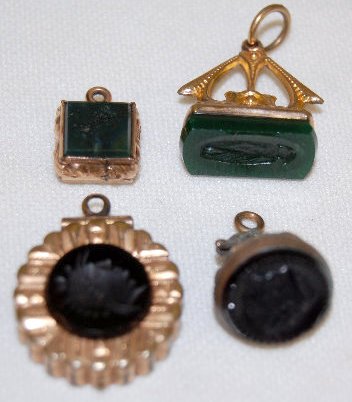 4 Watch Chain Charms, Intaglio & Relief: 4 Watch Chain Charms, Intaglio & Relief: 3 intaglio and 1 in relief; 2 are seal style; 1 is a locket with classic profile; the smallest is tan. (The smallest is missing a jewel above the head.) All se