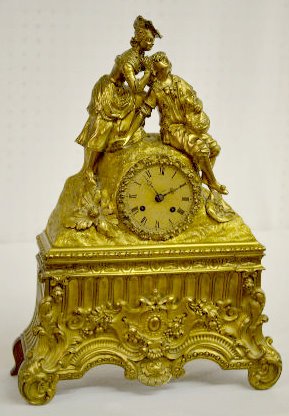 Bacilier & Fils Paris Mantel Clock w/Man & Woman: Bacilier & Fils Paris Mantel Clock w/Man & Woman: In the style of Charles X. The silk string movement strikes a cup bell. The brass dial sits below a man and woman in early dress. The case front has G