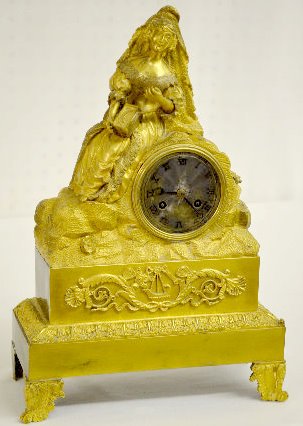 French Gilt Bronze Silk String Clock w/Lady: French Gilt Bronze Silk String Clock w/Lady: The unnamed movement strikes on a bell for the hour and 1/2 hour. A well dressed woman on a rock like mound holds a box on her lap and a tassel in her rais