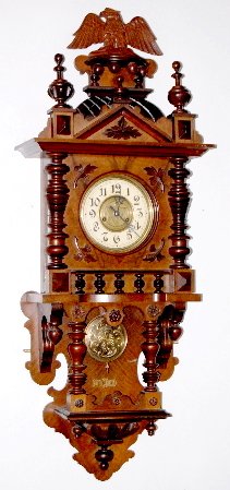 Carved German Open Well Clock w/Eagle: Carved German Open Well Clock w/Eagle: ivory chapter ring dial with molded metal center dial and a fancy hops and leaves decorated pendulum; carved bird crest with leaves and rosette decorations. Not 
