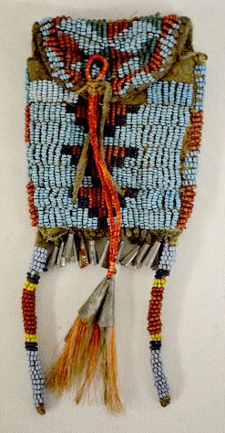 Plains Tribe Old Beaded Hide Bag: Plains Tribe Old Beaded Hide Bag: With geometric designs in light blue, black, red and green. The decorative tassels on the flap are wrapped with red material and has tin cones and horse hair at the e