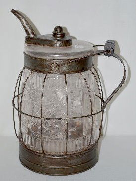 Antique Glass and Metal Oil Jug: Antique Glass and Metal Oil Jug: The glass jug, framed in a metal band and wire cage, has a pattern that is similar to Princess Feather. The wire cage has a bail handle with a wooden grip. The metal s