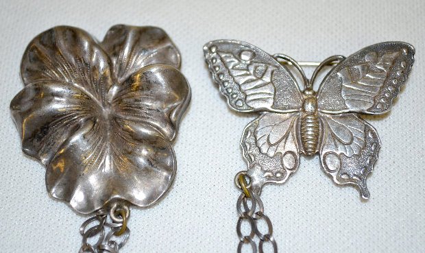 Sterling Chatelaine Flower & Butterfly Pin: Sterling Chatelaine Flower & Butterfly Pin: A butterfly is connected to the chain that ends with a pansy like flower. This is a very nice piece. 8" Long Sells as is, where is.