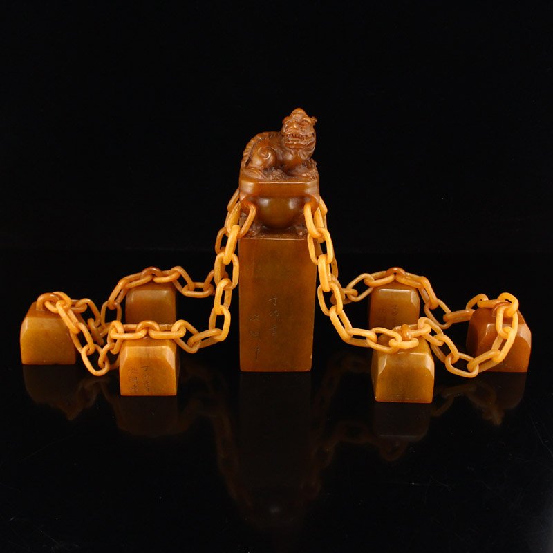A Set Vintage Shoushan Stone Tian Huang Stone Seals: Set of vintage shoushan stone and Tian Huang stone seals. The central seal towers above the rest, topped with a fierce fortune beast. The six other seals are attached by masterfully crafted openwork c